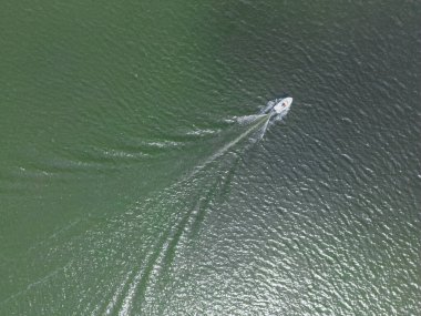 View from a drone, the boat floats on the lake leaving a trail behind it. High quality photo