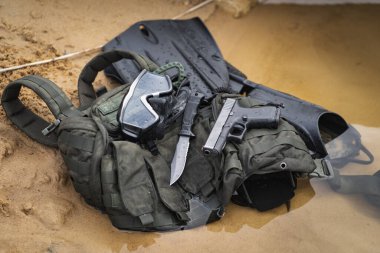 Underwater equipment and weapons of a combat swimmer on the sandy shore of a reservoir. High quality photo