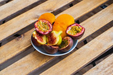 Sliced ??fruits in a plate on a table on the terrace, papaya, figs and peaches. High quality photo