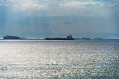 Marine logistics, tankers and container ships approaching the port of Athens. The sky is overcast. High quality photo