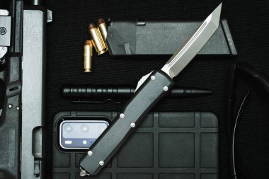 Tactical equipment and a folding knife with a tatno-shaped blade. High quality photo