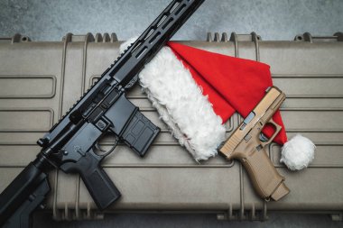 New Year theme and firearms. Santa Claus hat, camouflage pistol and ar 15 rifle. High quality photo