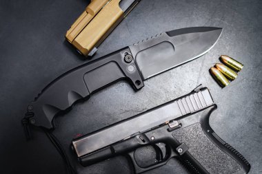 Firearms and bladed weapons, pistols and a folding tactical knife, close-up photos. High quality photo