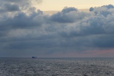 Seascape in the Baltic Sea at sunset. A tanker ship at sea, the sky is overcast. High quality photo