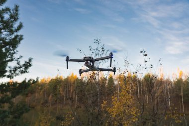 Quadcopter with camera in the air in nature in autumn. High quality photo