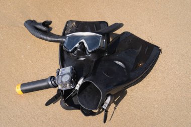 Snorkeling equipment and action camera on a selfie stick on the sandy beach. High quality photo