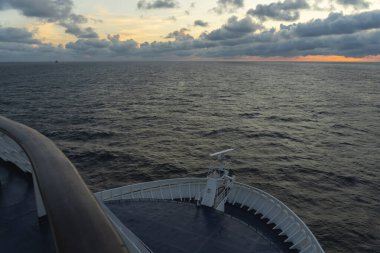 Maritime logistics. The bow of a cruise ship on the open sea with a view of the horizon after sunset. Wide angle lens. 