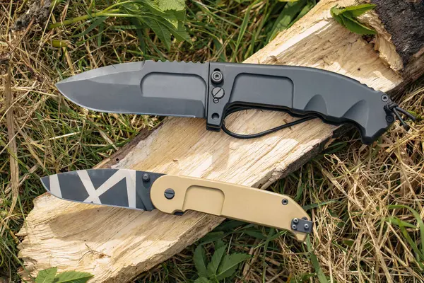 Tactical folding knives in nature, close-up photo. High quality photo
