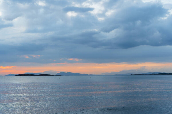 Greek seascape at sunset, storm clouds over the islands. The calm before the storm.