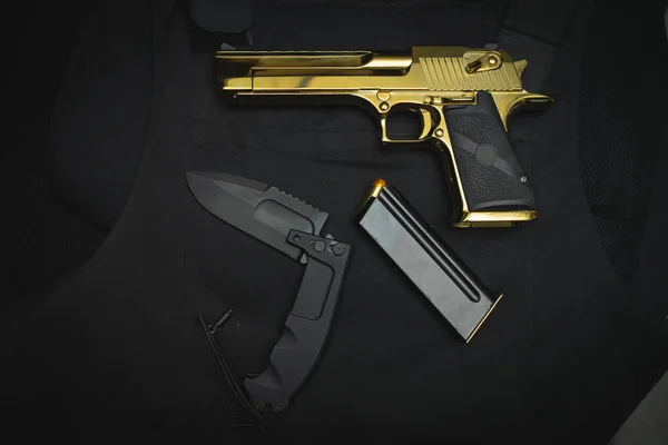 Firearms and bladed weapons. Desert Eagle pistol and large folding tactical knife. High quality photo