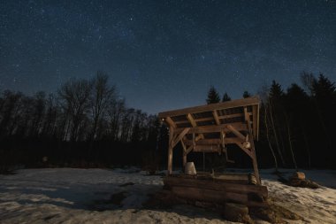 Gece sahnesi, manzara astrofotografı, yıldızlı bir gökyüzü ile ormandaki eski kuyu.. 