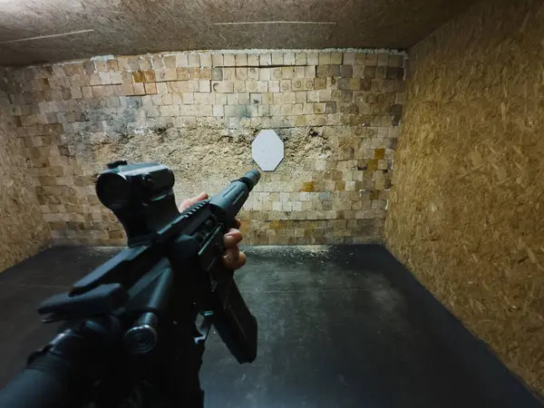 Tactical shooting from an Ar15 rifle at a shooting range, first-person photo.