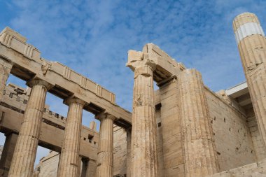 Yunan akropolünde sütunlar bulutlu mavi gökyüzünün arka planına karşı. 
