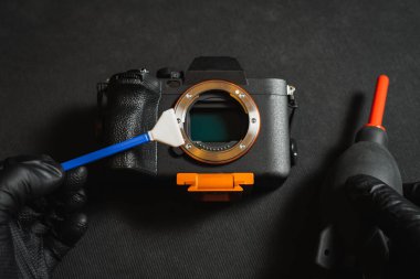 Professional sensor cleaning on a mirrorless camera, close-up photo.  clipart