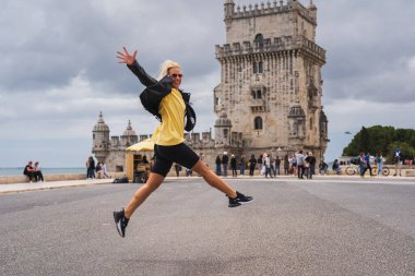 Portekiz, Lizbon 17 Mayıs 2024. Bir kız, bir turist, bir atlet, Nike giysileri giyiyor, Belem kulesinin yanında hoplayıp zıplıyor.. 