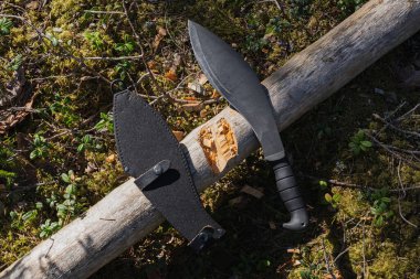 Ormandaki bir kamp alanında odun kesmek için taktik kukri.. 
