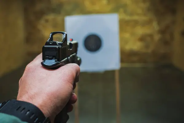 Atış poligonundaki bir hedefe kırmızı noktalı bir silahla ateş etmek.. 