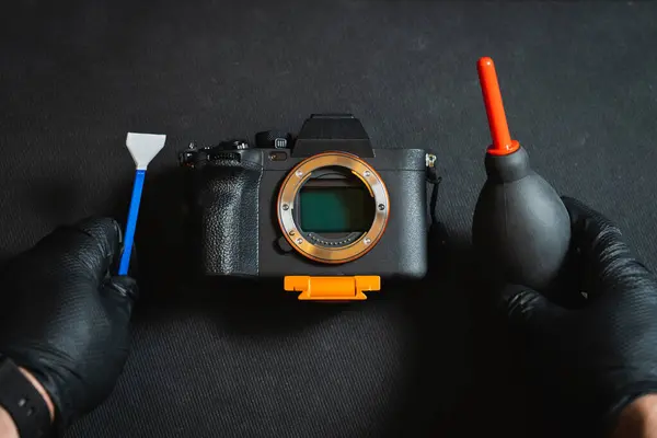 stock image Cleaning the sensor of a photo camera. Male hands in rubber gloves hold a camera sensor maintenance kit. 
