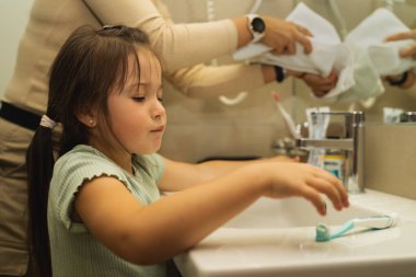 Sabah 6 yaşında küçük bir kız dişlerini banyoda fırçalayacak. Yüksek kalite fotoğraf