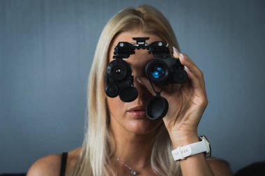 Kız gece görüş gözlüklerine, yakın çekim fotoğrafına, portreye bakıyor.. 