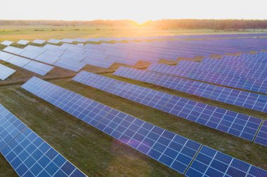 Yazın gün batımında bir tarlada güneş panelleri, Estonya 'daki bir dronun fotoğraf görüntüsü.. 