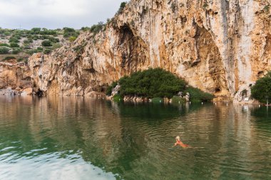 Bir kız Vouliagmeni mineral termal gölünde banyo yapıyor.. 