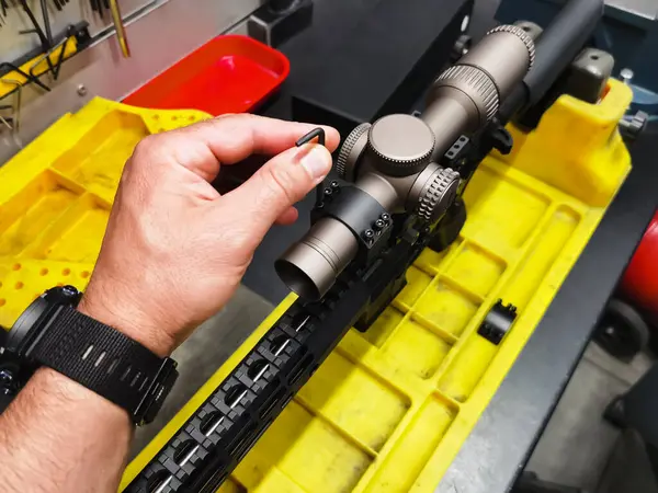 Atölyedeki bir tüfeğe optik görüş yerleştirmek. 