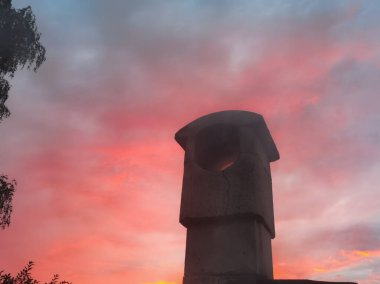 Güneş batarken gökyüzüne doğru yükselen bir taş ocağın borusu, Estonya 'nın doğası.. 