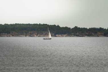 Vaike Pakri adası yakınlarındaki Baltık Denizi 'nde bir yaz akşamı bulutlu bir havada yelken açmak..