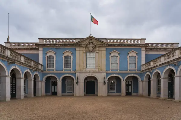 stock image Portugal Lisbon May 15, 2024. Queluz National Palace backyard, the sky is overcast with Portuguese flag on the building. 