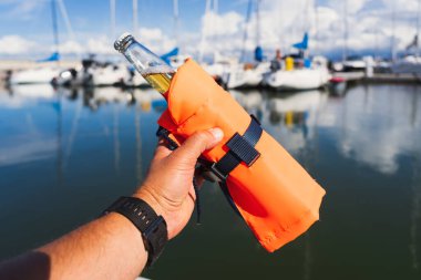 Bir yaz günü limanda bir adamın elinde can yeleğinde bir şişe bira..