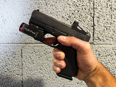 Baltık Devletleri, 19 Ağustos 2024. Kırmızı noktalı ve taktiksel fenerli Glock 43x mos tabancası.