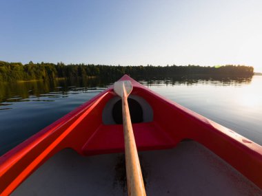 Sonbaharda günbatımında Estonya 'nın Rummu taş ocağında kano ve kürek çekin..