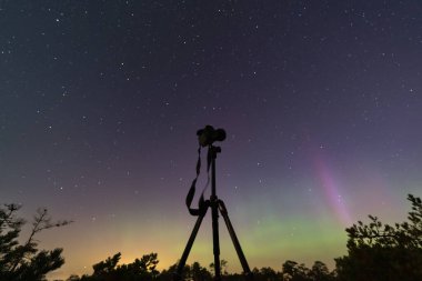 Gece astrofotografı, bir tripodun üzerindeki aynasız kamera kuzey ışıkları ve yıldızlı gökyüzü boyunca.