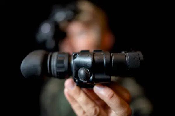 stock image A special forces soldier iwith a night vision device in hand on a black background.