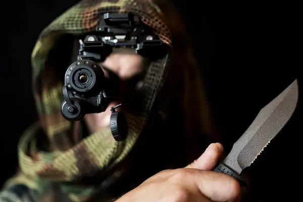 stock image A soldier in camouflage, with a night vision device and a knife in his hand.