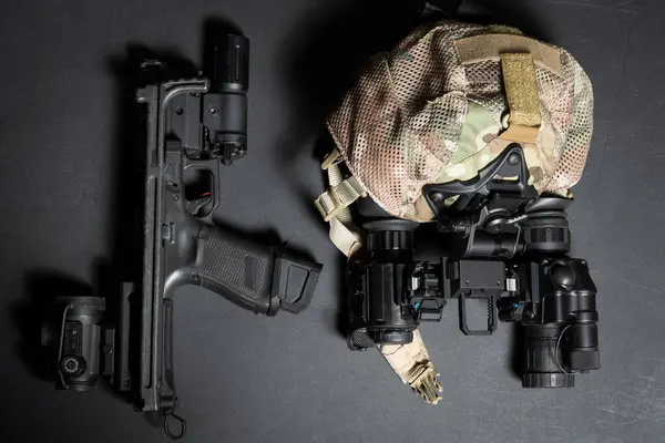 stock image Tactical gear and weapons, cap and binocular night vision device, pistol with buttstock, red dot sight and flashlight.