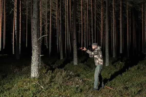 stock image A soldier with a night vision monocular on his head and an assault rifle ak in his hands in a dark forest. 