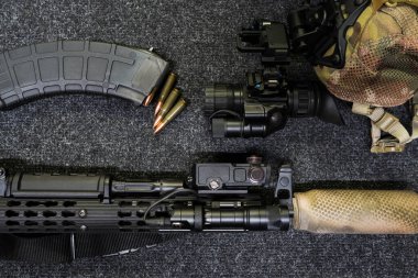 Taktik ekipman, susturuculu tüfek, el feneri, lazer görüş / kızılötesi, mühimmat, şarjör ve gece görüş cihazı..