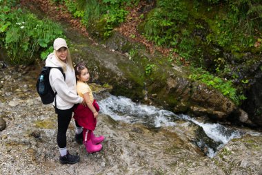 Bir yaz günü Polonya Tatraları 'ndaki Zakopane Milli Parkı' nda bir dere kenarında anne ve kız yürüyüşçüler.. 