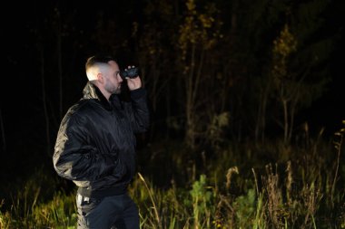 Karanlık bir ormanda elinde gece görüş cihazı olan bir adam.. 