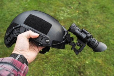 Bir adamın elinde gece görüşü cihazı olan taktik siyah başlık, yakın plan fotoğraf..