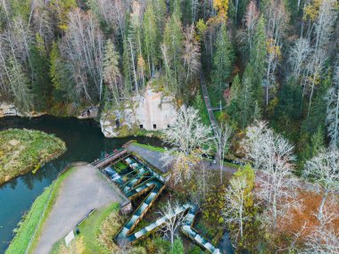 Fish ladder and sandstone caves on the Ligatne River, a tributary of the Gauja in Latvia. Drone view.  clipart