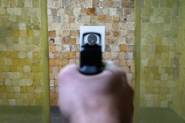 Bir atış poligonunda kağıt hedefe kırmızı noktalı bir silahla ateş etmek..