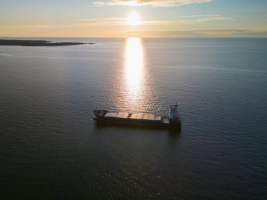 Deniz taşımacılığı, gün batımında Baltık Denizi 'ne demir atmış boş konteynır gemisi, İHA' dan çekilmiş fotoğraf.. 