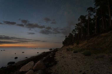 Eylül 'de gece sahnesi, Pedassaar adasının kumlu kıyısı, yıldızlı gökyüzü, samanyolu ve Finlandiya Körfezi.