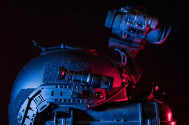 Gece görüş cihazı olan bir miğfere takılı taktik el feneri, karanlıkta yakın plan fotoğraf..