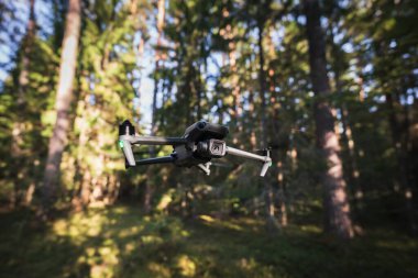 Bir yaz günü ormanda uçmakta olan, büyük, yüksek kaliteli kameralı bir kuadkopter drone..