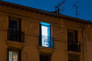 France, Nice, 17 Temmuz 2024. Gece şehri, bir apartmanın penceresinden gelen parlak mavi ışık. Yüksek kalite 