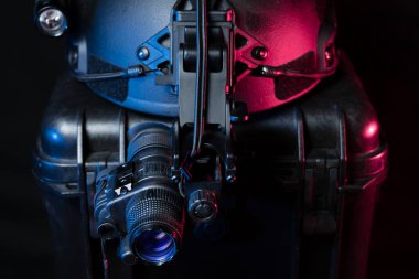 Gece görüşü mini monoküler taktik siyah bir miğfere monte edilmiş, karanlıkta yakın plan fotoğraf..